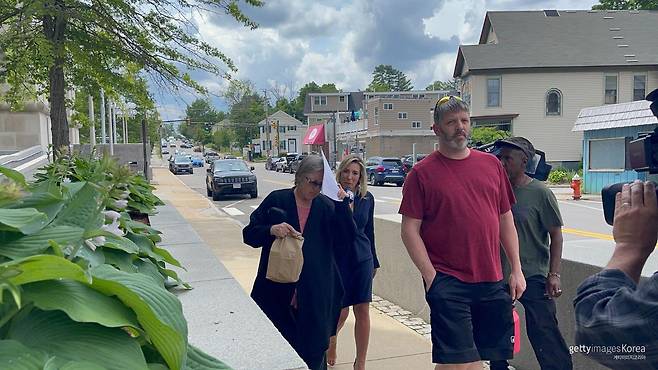 023년 6월 14일(현지 시간) 미국 뉴햄프셔주 콘코드의 연방 법원에서, 기증 시신 불법 거래 혐의로 체포된 데니스 로지가 공소장 사본으로 얼굴을 가린 채 법원을 나서고 있다. 게티이미지