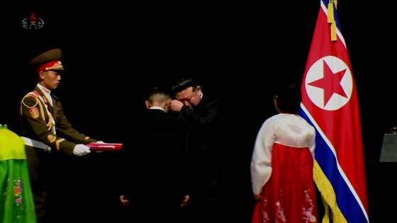 김 위원장이 우크라이나 전쟁의 전사자 유가족을 만나 눈물을 닦고 있다. [사진 조선중앙TV 캡처]