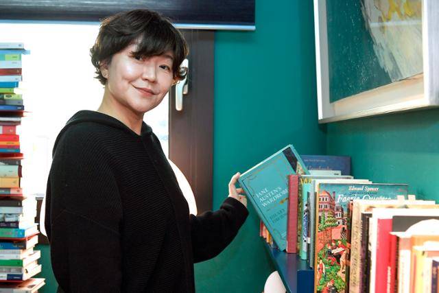 국내 대표 영문학 번역 전문가인 김선형 번역가가 12일 서울 종로구 자택 서재의 서가에서 제인 오스틴 책을 짚고 있다. 그는 "결혼 당시 남편과 '책이 방 하나에서 넘치지 않게 하겠다'는 약속했다"며 "읽은 책은 정리하고, 아직 읽지 않은 책 위주로 꽂아두는데, 제인 오스틴 책은 여기 그대로 꽂아 두고 있다"고 말했다. 임지훈 인턴기자