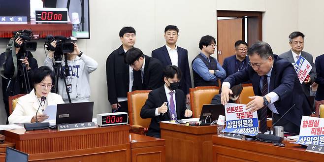 국회 과학기술정보방송통신위원회 국민의힘 의원들이 10월29일 서울 여의도 국회에서 열린 국정감사에서 최민희 위원장을 규탄하는 피켓을 노트북에 부착하고 있다. /뉴시스
