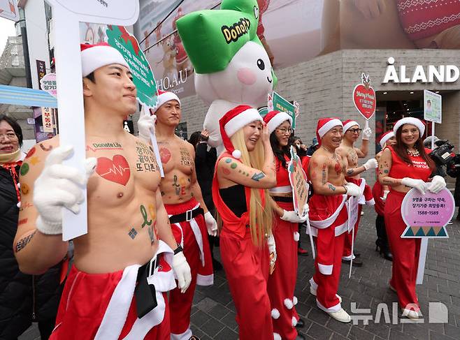 [서울=뉴시스] 배훈식 기자 = 산타 복장을 한 스포츠 트레이너들이 19일 오전 서울 중구 명동거리에서 사랑의장기기증운동본부 '나인퍼레이드'를 하고 있다. '놔사 시 장기기증으로 9명의 생명을 구한다'는 의미를 담은 나인(9)퍼레이드'는 지난 2015년부터 해마다 성탄절을 앞두고 장기 이식을 기다리는 환자들에게 희망을 전하기 위해 열리고 있다 2025.12.19. dahora83@newsis.com