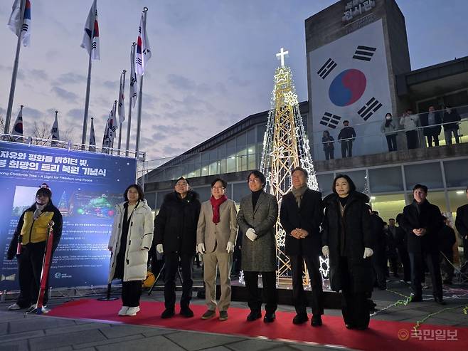 김병수 김포시장이 20일 김포시 애기봉평화생태공원 전시관 앞에서 11년 만에 부활한 '성탄 철탑 트리' 점등식을 진행하고 내빈과 기념촬영을 하고 있다. 박재구 기자