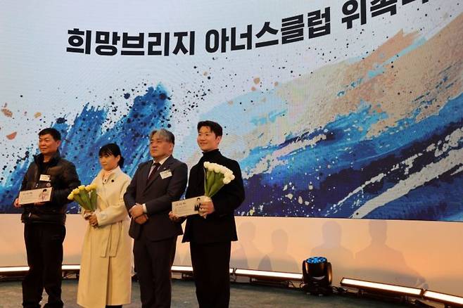 '임팩트 나잇 2025'에서 프로게이머 '쵸비' 정지훈과 파나타 김어진 COO를 희망브리지 고액 기부자 모임인 '아너스클럽 위촉식'을 진행했다(왼쪽부터)'쵸비' 정지훈 부모님, 희망브리지 임채청 회장, 파나타 김어진 COO. 희망브리지