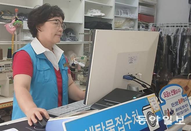 자신의 세탁소에서 세탁물을 접수하고 있는 용성옥 씨.