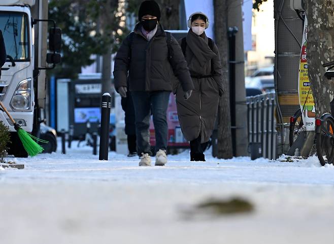 전날 내린 폭설과 계속되는 한파로 도로 곳곳이 얼어붙은 가운데 5일 오전 서울 용산구 한 이면도로에서 시민들이 빙판길을 조심히 걷고 있다.   이상섭 기자