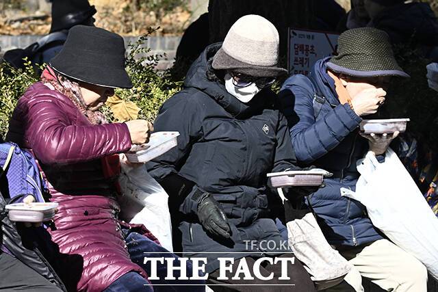 22일 오전 서울 종로구 조계사를 찾은 방문객들이 팥죽을 먹고 있다.