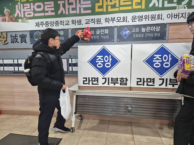 제주 중앙중학교 한 학생이 '사랑의 라면 트리' 기부함에 라면을 넣는 모습 (학부모회 제공)