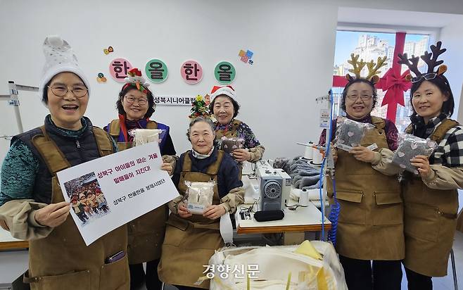 서울 성북구 종압동 행복한 세탁소 수선방에서 일하는 어르신 6명이 22일 직접 만든 목도리를 들고 기념촬영하고 있다. 류인하 기자