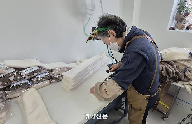 1차 봉제를 마친 목도리가 다림질 작업을 거치고 있다. 류인하 기자