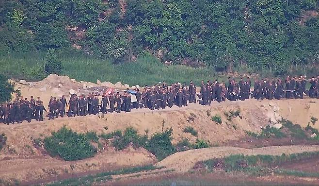 The photo, provided by the Joint Chiefs of Staff on June 18, 2024, shows North Korean troops mobilized in large numbers to carry out border defense activities, including land clearing, mine emplacement, reinforcement of tactical roads, and the installation of unidentified structures believed to be anti-tank barriers. (Joint Chiefs of Staff)