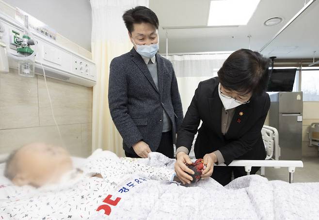 정은경(오른쪽) 보건복지부 장관이 이윤환 경도병원 이사장과 함께 환자를 묶어두는 대신 개량된 장갑으로 환자 손을 보호 중인 장치를 살펴보고 있다.(사진=보건복지부)