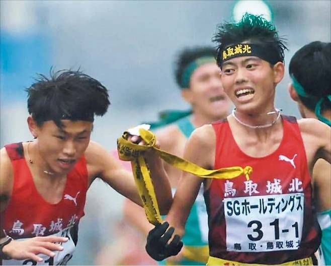 지난 21일 일본 고교 역전 마라톤 대회에서 돗토리조호쿠고 1번 주자 혼다 오지로(오른쪽)가 다음 주자인 야마네 소라에게 바통을 넘기고 있다./게츠리쿠온라인