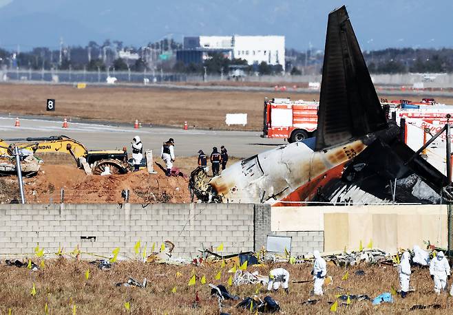 제주항공 여객기 참사 엿새째인 지난 1월 3일 오후 전남 무안국제공항 참사 현장에서 국과수 관계자들이 로컬라이저(방위각시설) 둔덕에 파묻힌 엔진을 살펴보고 있다. /뉴스1