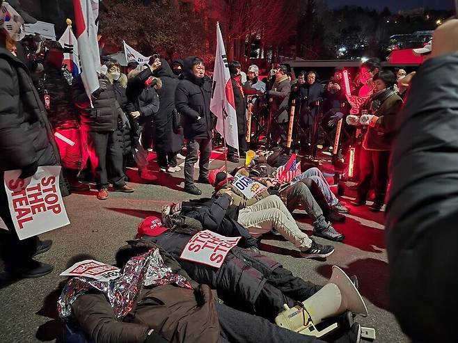 ‘12·3 내란 사태’를 수사한 공조수사본부가 윤석열에게 체포영장을 재집행한다는 소식이 전해진 2025년 1월14일 밤 11시, 서울 한남동 대통령 관저 앞에 윤석열 지지자들이 드러누워 있다. 한겨레 김가윤 기자 gayoon@hani.co.kr