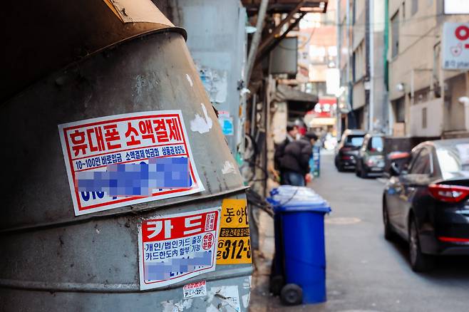 팍팍한 경기 고금리와 불경기 등으로 지난해 자영업자 연체율이 역대 최고치를 기록했다. 22일 서울 종로 거리에 신용카드 대납·대출 광고 스티커가 붙어 있다.  이준헌 기자 heon@kyunghyang.com