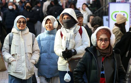 Tourists walk down the streets of Myeongdong, central Seoul, on Dec. 21, 2025. [NEWS1]