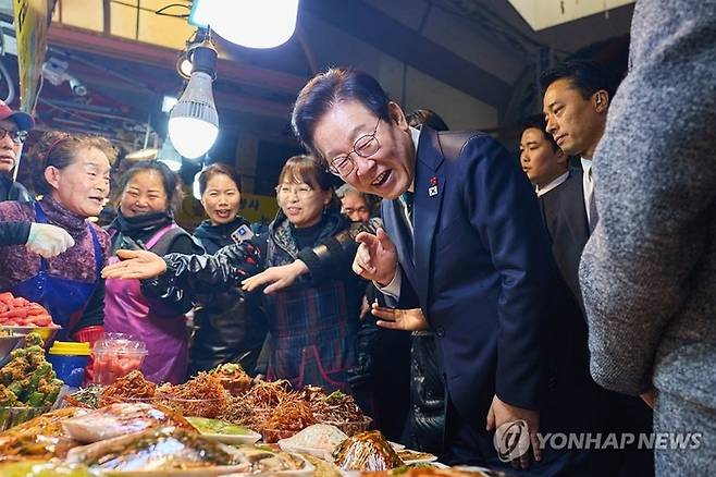이재명 대통령이 23일 해양수산부 청사에서 국무회의를 마친 뒤 부산 부산진구 부전시장을 찾아 상인들과 이야기를 나누고 있다. 2025.12.23 [대통령실 제공]