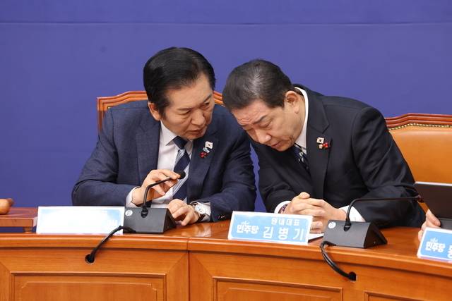 더불어민주당의 정청래(왼쪽) 대표와 김병기 원내대표가 22일 오전 국회에서 열린 최고위원회의에서 귓속말로 대화하고 있다. 연합뉴스