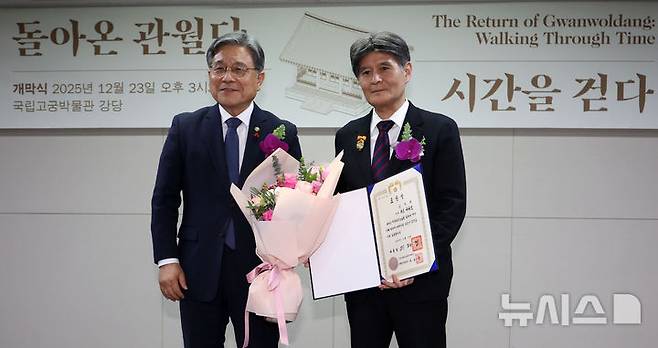 [서울=뉴시스] 김선웅 기자 = 허민 국가유산청장이 23일 서울 종로구 국립고궁박물관에서 열린 '돌아온 관월당 : 시간을 걷다' 특별전시 개막식에서 관월당을 기증한 일본 고덕원 사토 다카오 주지에게 대통령 표창을 수여하고 있다.국가유산청과 국외소재문화유산재단은 광복 80주년을 기념해 24일부터 경복궁 계조당에서 '돌아온 관월당 : 시간을 걷다' 특별전을 개최한다. 관월당은 조선 후기에 만들어진 왕실 관련 사당 추정 목조 건축물이다. 일제강점기에 일본으로 반출돼 도쿄를 거쳐 가마쿠라시 소재 사찰 고덕원 경내에 약 100년간 머물렀으며 지난 6월 고덕원 주지 사토 다카오의 기증으로 약 100년 만에 환수됐다. 전시에서는 관월당의 종량, 대공, 초엽 등 부재가 공개된다. 2025.12.23. mangusta@newsis.com