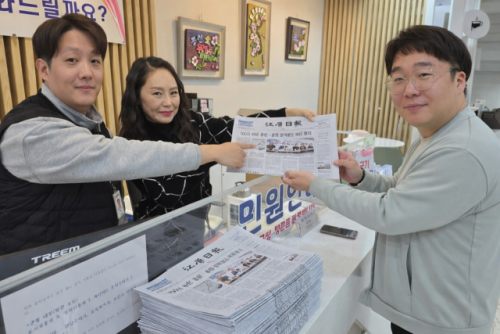 ◇홍천군청 직원들이 23일 용문~홍천 광역철도 사업 확정 기사가 실린 강원일보를 보고 있다. 사진=신하림기자