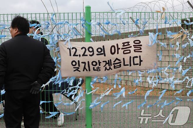 12·29 제주항공 여객기 참사 1주기를 앞둔 24일 전남 무안국제공항에서 시민들이 추모 리본을 작성해 달고 있다. 2025.12.24/뉴스1 ⓒ News1 박지현 기자