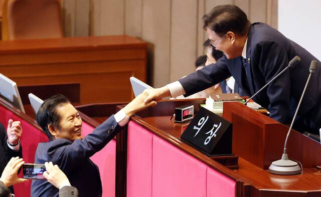 우원식 국회의장이 24일 국회에서 열린 12월 임시국회 본회의에서 전날 상정된 허위조작근절법에 대한 무제한 토론(필리버스터) 종결을 위한 투표를 마친 정청래 더불어민주당 대표와 악수하고 있다. 김경호 선임기자 jijae@hani.co.kr