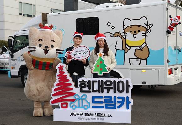 현대위아 직원들이 지난 23일 경상남도 창원시 현대위아 본사 앞에서 지역 사회복지기관 10곳에 선물할 ‘현대위아 드림카’와 함께 기념 사진을 찍고 있다. [사진=현대위아]