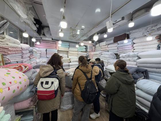 지난 22일 서울 종로구 광장시장에서 관광객들이 이불을 구경하고 있다. 곽주영 기자