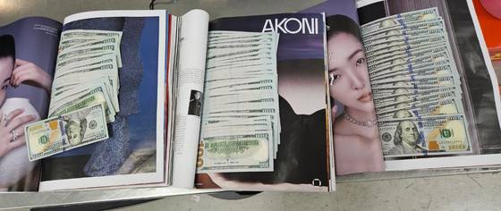 잡지에 달러 뭉치를 숨겨 나가려던 출국객이 인천공항 보안검색에서 적발됐다. 사진 인천공항 보안검색 노조