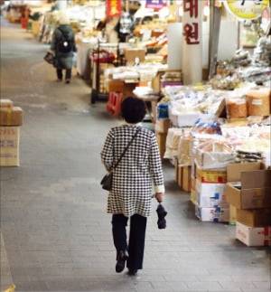 지난달 27일 서울의 한 전통시장을 찾은 시민이 장을 보고 있다.  뉴스1