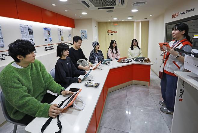 Six adults take on the role of newsroom reporters at a booth partnered with the JoongAng Ilbo at KidZania in Jamsil, southern Seoul, on Dec. 20. [PARK SANG-MOON]