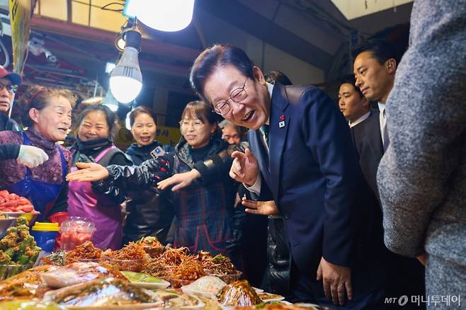 [서울=뉴시스] 이재명 대통령이 23일 부산진구 부전시장을 방문해 상인들과 만나 대화를 나누고 있다. (사진=대통령실 제공) 2025.12.23. photo@newsis.com *재판매 및 DB 금지 /사진=