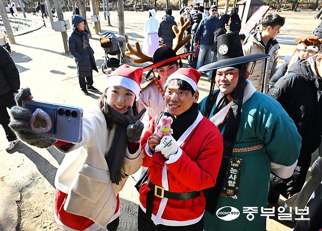 크리스마스를 맞은 25일 오후 용인시 한국민속촌에서 열린 '운좋은 산타' 행사에서 산타복을 입고 행사장을 찾은 시민들이 루돌프와 기념촬영을 하며 즐거운 시간을 보내고 있다. 김경민기자