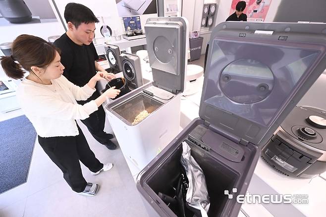 서울 송파구 쿠쿠 잠실직영점에서 고객이 미생물을 이용한 제품과 건조분쇄형 음식물처리기를 살펴보고 있다. 박지호기자 jihopress@etnews.com