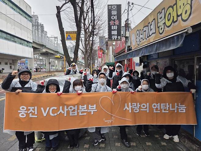 웅진그룹 임직원들이 지난 23일 서울 노원구에서 연탄 나눔 봉사활동에 앞서 기념 촬영을 하고 있다. 웅진그룹 제공