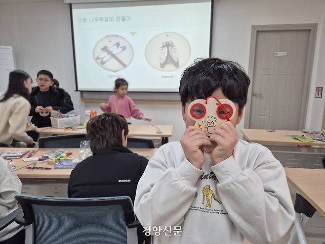 무학숲도서관 생태 교육 프로그램에 참여한 초등학생이 ‘곤충 눈’ 렌즈 체험을 하고 있다. 반기웅 기자