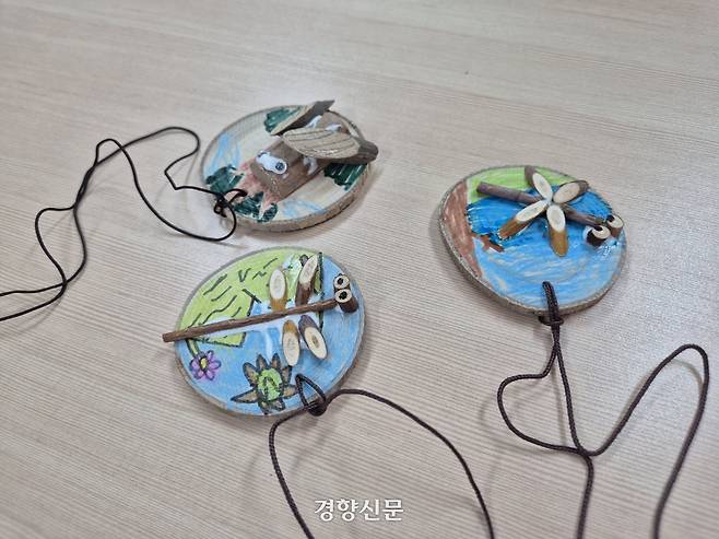 무학숲도서관 생태 교육 프로그램에서 초등학생들이 만든 곤충 나무 목걸이.  반기웅 기자