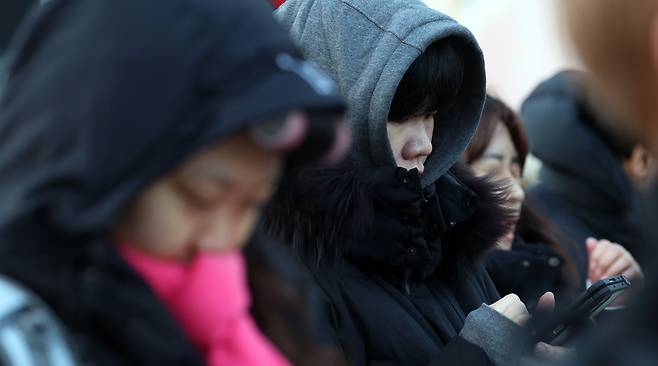 People are seen waiting to cross a street near Gwanghwamun Square in Jongno District, central Seoul, on Dec. 12. [NEWS1]