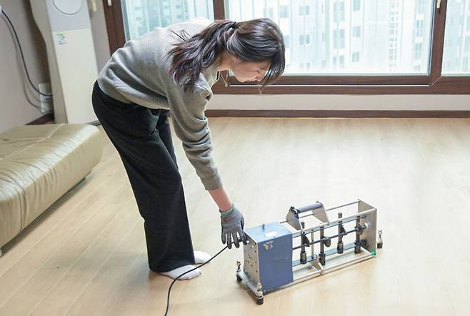 지난 18일 경기도 고양시 일산의 한 아파트에서 한국건설생활환경시험연구원(KCL) 소속 연구원이 경량충격음을 발생시켜 소음 저감 효과를 측정하고 있다. <현대L&C>