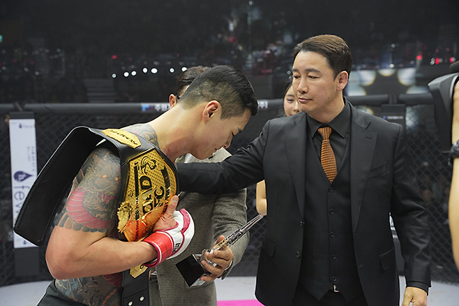 제8대 로드FC 미들급 챔피언 황인수(왼쪽)가 2025년 3월 서울특별시 중구 장충체육관에서 통합 챔피언 등극 및 타이틀 1차 방어 성공 후 정문홍 대한MMA총협회장한테 인사하고 있다. 사진=세계격투스포츠협회