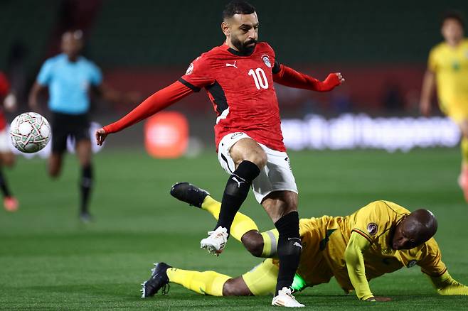 Egypt's forward #10 Mohamed Salah and Zimbabwe's defender #02 Gerald Takwara compete for the ball during the Africa Cup of Nations (CAN) group B football match between Egypt and Zimbabwe at Adrar Stadium in Agadir on December 22, 2025. (Photo by FRANCK FIFE / AFP)<저작권자(c) 연합뉴스, 무단 전재-재배포, AI 학습 및 활용 금지>
