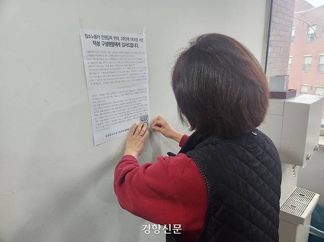 지난 12월 23일 덕성여대 청소노동자가 ‘인원 감축 반대’ 서명에 참여해준 학생들에게 감사하다는 내용의 노조 인사말을 학교 건물 벽에 붙이고 있다. 이혜리 기자