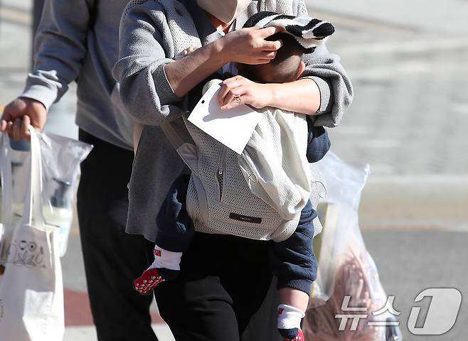 엄마가 찬바람을 가리기 위해 아기에게 털모자를 씌워주고 있다. 2025.12.4/뉴스1 ⓒ News1 공정식 기자