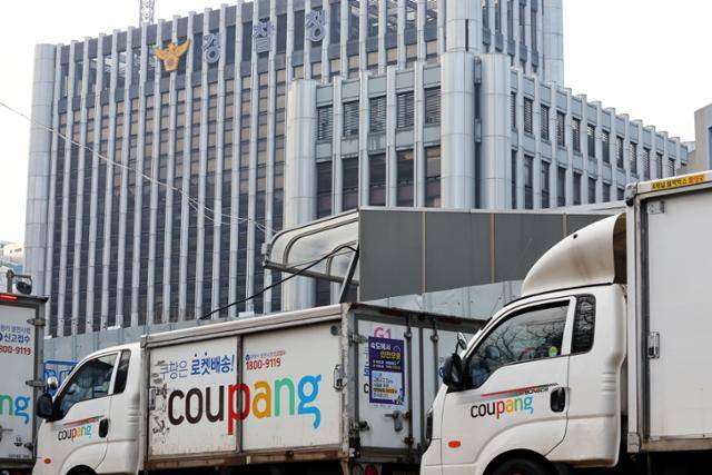 28일 서울의 한 쿠팡센터 앞에 주차된 쿠팡 배송차량들 너머로 경찰청이 보인다. 뉴스1