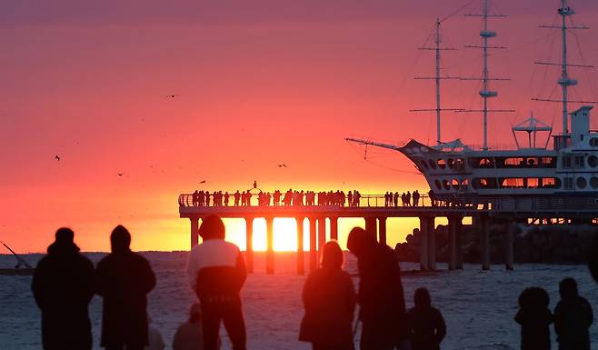 Visitors are seen enjoying the sunrise at Jeongdongjin Beach in Gangneung, Gangwon on Dec. 21. [YONHAP]