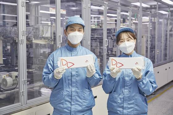 SK On engineers pose with pouch-type batteries [SK ON]