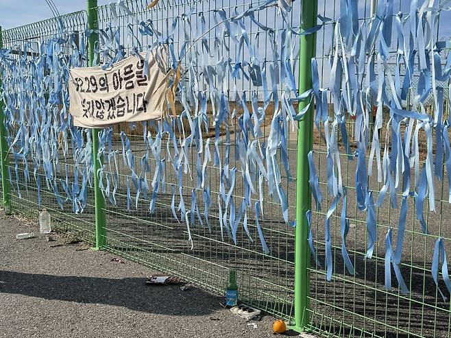 Light blue memorial ribbons are seen tied to fence near the runway of Muan International Airport in South Jeolla on Dec. 22. [LEE SOO-JUNG]