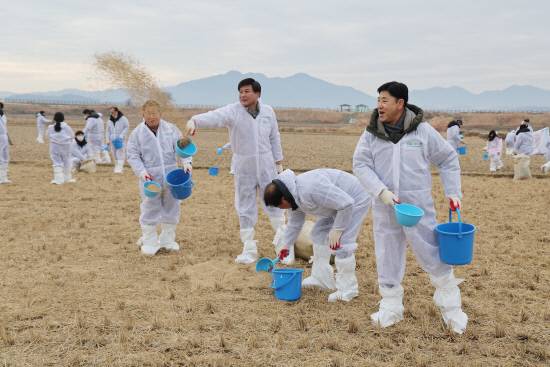 지난 28일 무학 최재호 회장과 무학 임직원으로 구성된 좋은데이 봉사단, 한국조류보호협회 창원지부 등 관계자들이 주남저수지에서 철새 먹이주기를 하고 있다.사진=무학