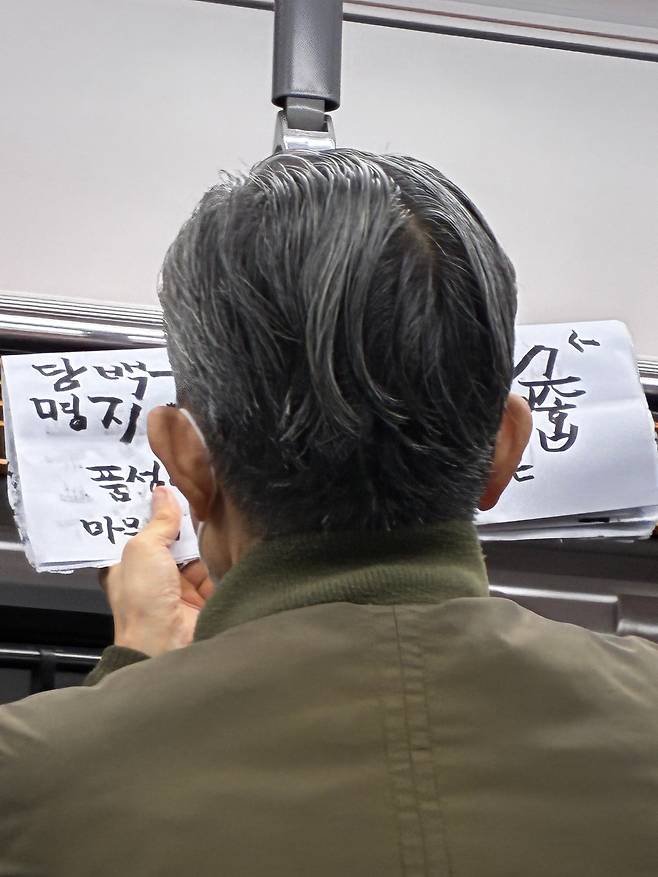 지하철에서 한문 글귀 쓰는 노인의 뒷모습. /정수윤 제공