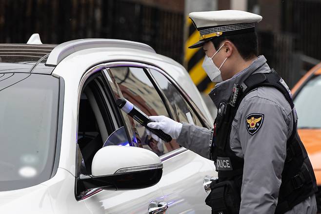 A police officer is seen conducting a drunk driving test in front of an elementary school in Seodaemun District, western Seoul, on March 5. [NEWS1]
